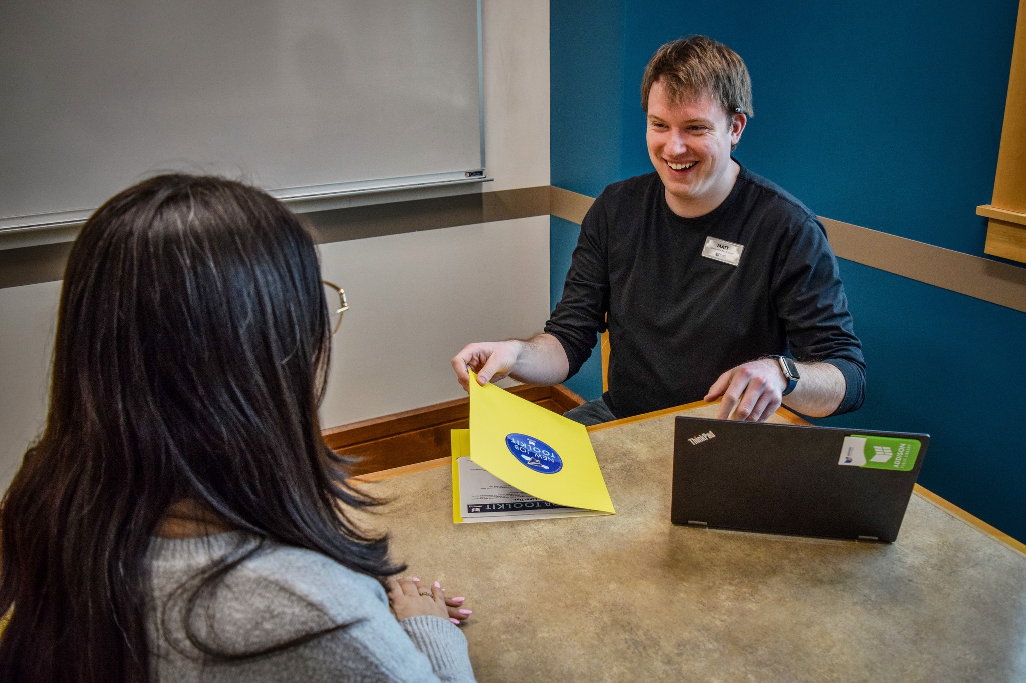 image showing a male librarian smiling with a female patron during an appointment