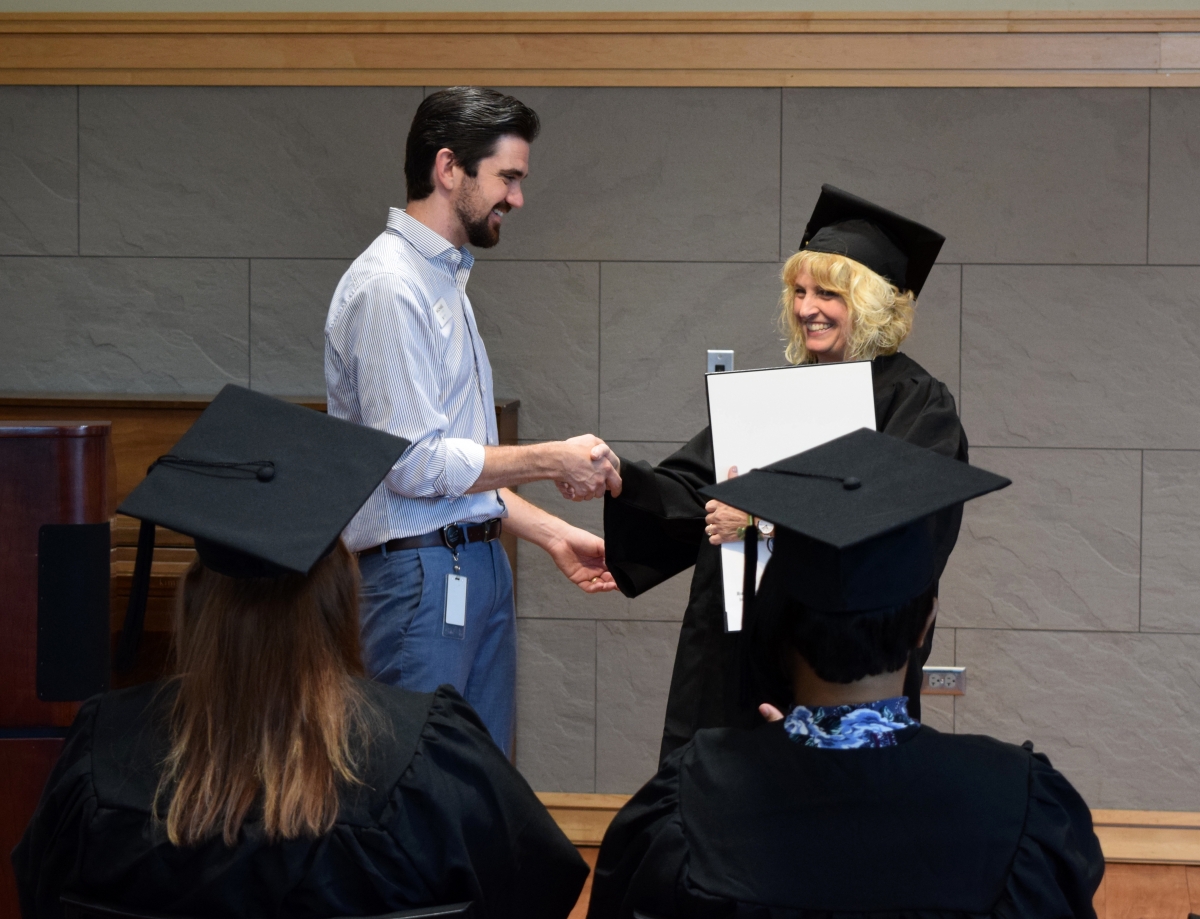 Photo of graduate shaking hands with library staff