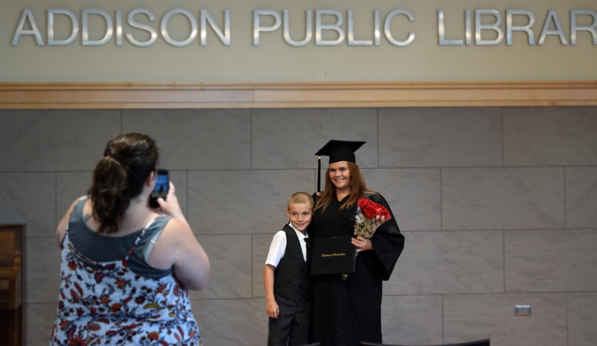 Photo of graduate posing with child for a photo