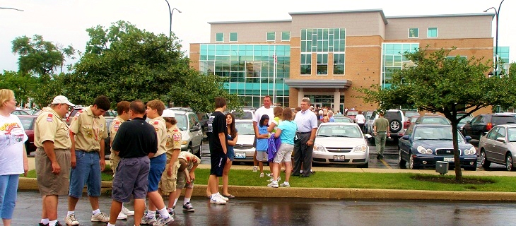 Photo of 4 Friendship Plaza and patrons helping move materials from 2 Friendship Plaza across parking lot