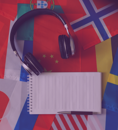 Photo of notebook, pencil, and headphones sitting on top of country flags