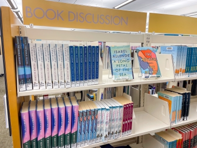 Photo of "Book Discussion" shelves located on the 2nd Floor. Shelves holding several rows of books.