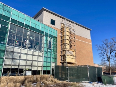 Library building with scaffolding and a trash chute on the exterior wall.