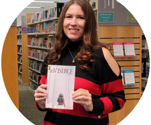 Photo of Laura McPherson holding her book "inVISIBLE."