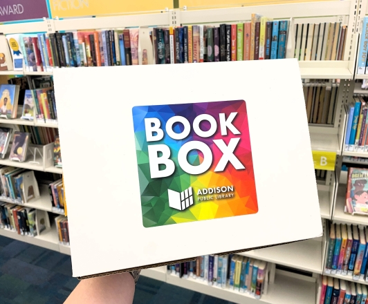 Photo of Book Box. A cardboard box labeled "Book Box" being held up by an unpictured person.