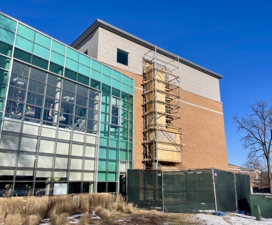 Library building with scaffolding and a trash chute on the exterior wall.