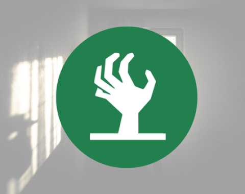 white icon of zombie hand on green circle