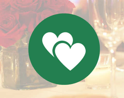 white icon of two hearts on green circle