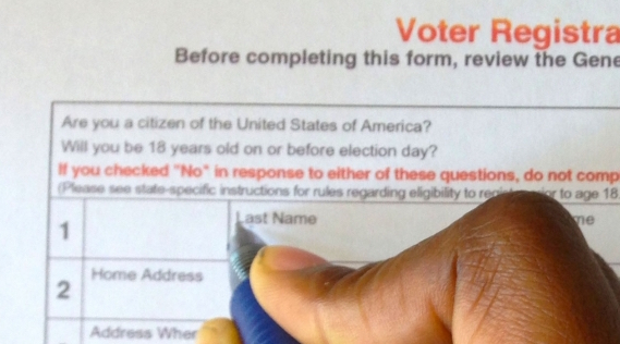 Close up of pen filling out paper voter registration form